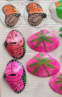 painted rocks with butterflies and palm trees on them