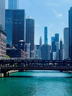 there is a bridge that goes over the water in front of tall buildings and skyscrapers