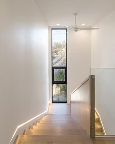 the stairs lead up to the second floor in this modern house with wood floors and white walls