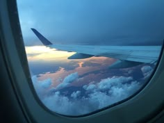 the view from an airplane window looking out at clouds and sunsets in the sky