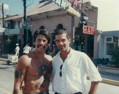 two men standing next to each other on the street