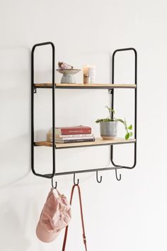 a shelf with two shelves holding books and a purse hanging from it's side