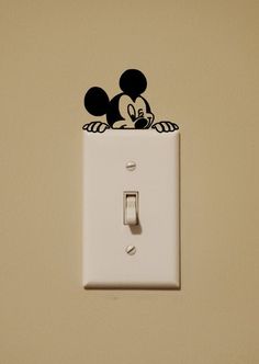 a mickey mouse light switch plate with a black and white sticker on it's cover