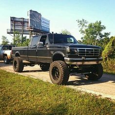 a black truck parked on the side of a road