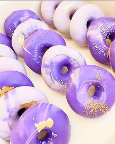 purple donuts with white frosting and sprinkles