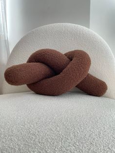 a brown and white knot sitting on top of a bed