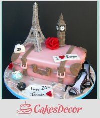 a pink cake with the eiffel tower in the background and luggage on top