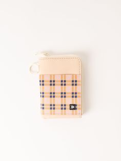 a small wallet with a keychain hanging from it's side on a white surface