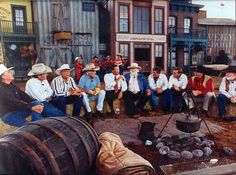 a group of men sitting around a fire pit