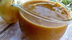 an apple cider is sitting on a wooden table next to some apples and grass