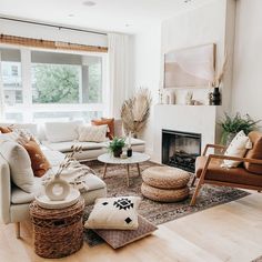 a living room filled with furniture and a fire place in front of a large window