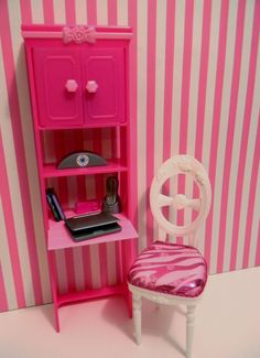 a pink dollhouse desk and chair next to a striped wallpapered room with stripes on the walls