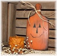 a wooden pumpkin sitting on top of a table next to a candle