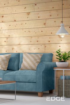 a blue couch sitting in front of a wooden wall