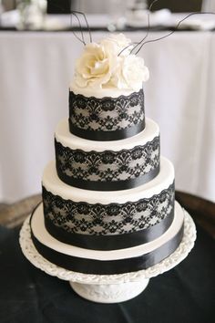 a black and white wedding cake with flowers on top