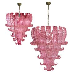 two pink glass chandeliers hanging from chains