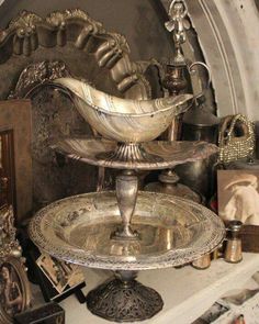 a silver plate sitting on top of a table next to pictures and other items in a room