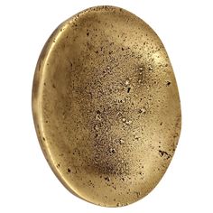 an oval brass plate with speckles on the surface, isolated against a white background