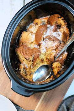 a crock pot filled with food on top of a wooden table