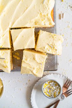 slices of cake sitting on top of a white plate next to small bowls and forks