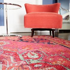 an orange chair sitting on top of a red rug