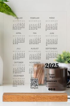 a desk with a calendar on it next to a potted plant