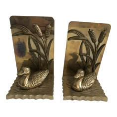 a pair of metal bookends depicting ducks in reeds