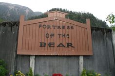 there is a sign that says fortresss of the bear in front of some flowers