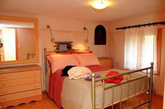 a bed room with a neatly made bed and dressers