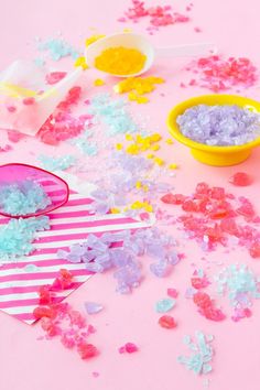 pink and blue confetti sprinkles next to two yellow bowls with spoons