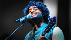 a man singing into a microphone while holding a guitar