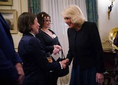 two women are shaking hands with another woman