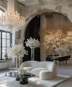 a living room filled with white furniture and chandeliers