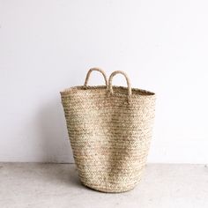 a large woven basket sitting on top of a white floor