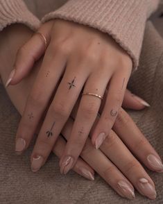 two hands with different designs on them and one has a cross tattooed on the middle finger