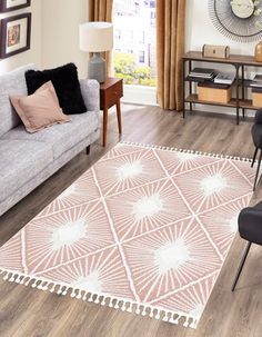 a living room filled with furniture and a white rug on top of a hard wood floor