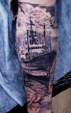 a man with a ship tattoo on his leg