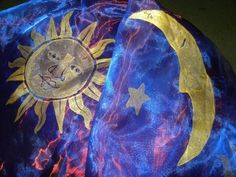 the sun and moon are painted on an old blue cloth with gold foiling,