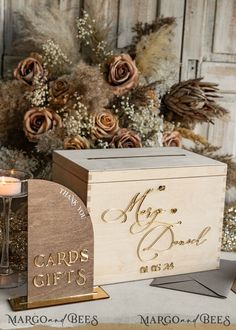 a wooden box with cards and a candle next to it on top of a table