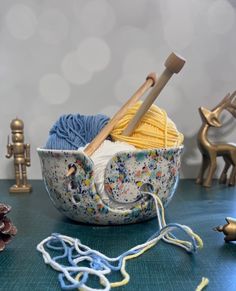 yarn and knitting needles in a bowl on a table