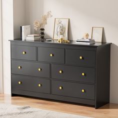 a black dresser with gold knobs in a room