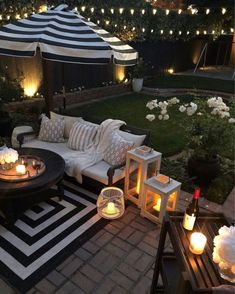 an outdoor seating area is lit up with candles