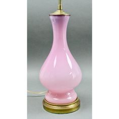 a pink glass lamp with a gold base