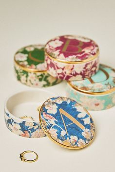 four different types of jewelry sitting next to each other on a white surface with a gold ring