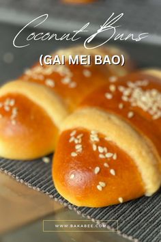 some bread is sitting on top of a cooling rack with the words coconut buns gai me bao