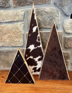 three triangle shaped wood pieces sitting on top of a wooden table