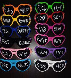 six pairs of heart shaped sunglasses with words written on them, all in different colors