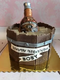 a birthday cake made to look like a barrel with a bottle in it and ribbon around the top