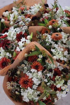 a bunch of flowers that are in some kind of potted planter on the ground