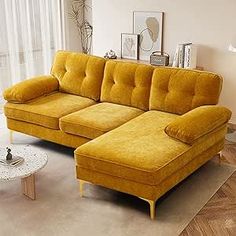 a living room with a yellow couch and coffee table on the floor in front of a large window